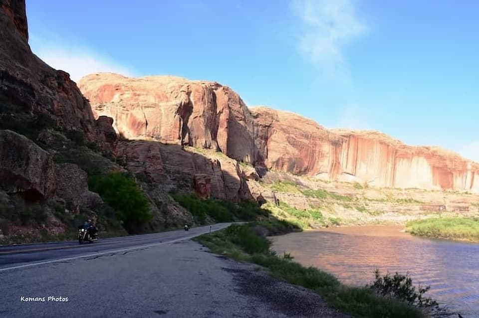 赤茶色の砂岩の絶壁とコロラド川の流れに挟まれたシーニック･バイウェイUT128号線を走る２台のバイクツーリスト